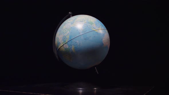 The globe rotates on a black background. Globe spinning on black screen. Slow motion	