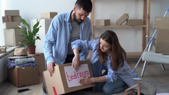 Young Couple Prepare Personal Stuff Relocating to First Own House Sealing Cardboard Boxes with