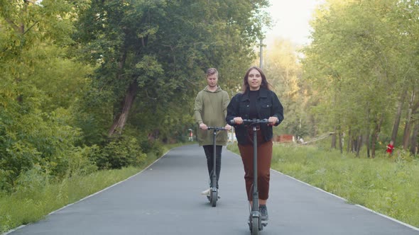 Happy Couple Arranged Competition for Riding Electric Scooters