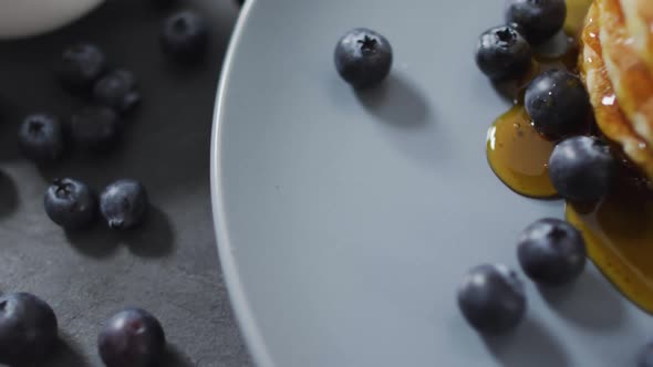 Video of pancakes on plate seen from above on wooden background