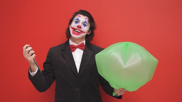 An Unusual Mysterious Magician Holding an Inflated Air Cushion on a Red Background a Magician in a