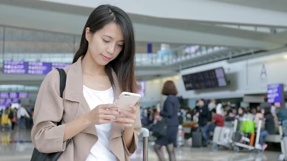 Woman using mobile phone in Hong Kong international airport