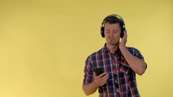 Happy Young Man Listening To the Music in Headphones, Singing and Dancing