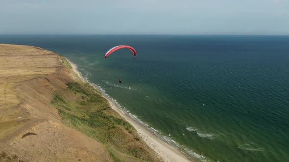 Stunning Sea and Sky in the Background of a Paraglider Flying in the Air