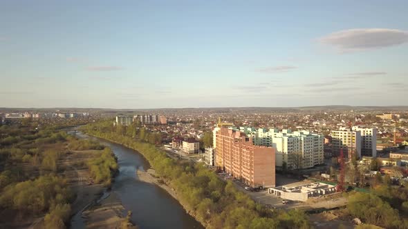 Aerial view of Ivano-Frankivsk city, Ukraine with Bystrytsia river and tall residential buildings 