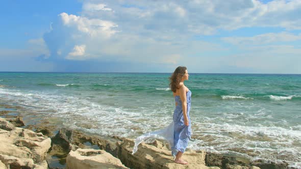 Pretty Brunette Enjoying Beautiful View on Sea Shore, Cloudy Sky Above Water