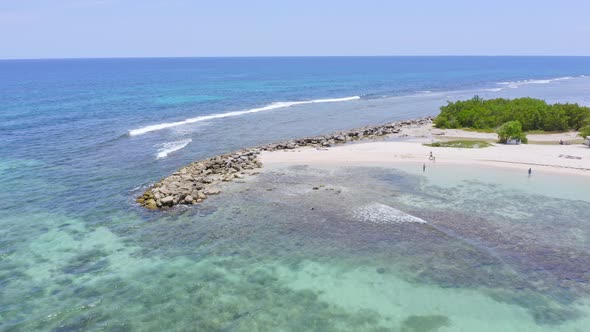 Fly over sandy beach and turquoise ocean water at Juan Dolio in Dominican Republic. Aerial