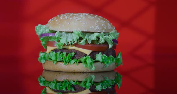 Classic Hamburger with Vegetables and Cheese on the Red Reflected Light in the Form of a Window.