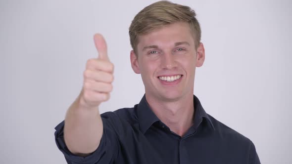 Face of Young Happy Blonde Businessman Giving Thumbs Up