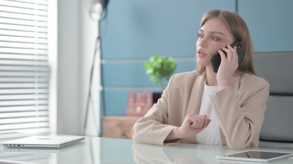 Businesswoman Talking on Smartphone in Office