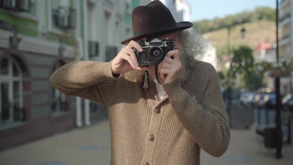 Portrait of Confident Elegant Senior Man Taking Photo and Looking at Camera. Positive Caucasian Male