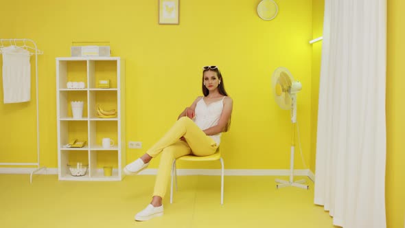 Portrait of Beautiful Woman Sitting In Yellow Interior