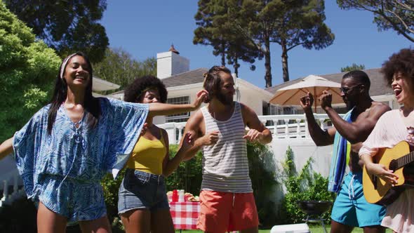 Diverse group of friends having fun and dancing at a pool party