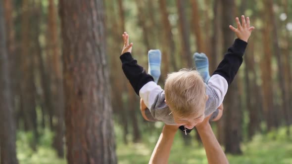 Happy family fun in the park in summer. Young parent father playing with his son