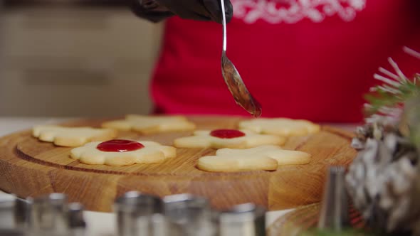 Close Up View of a Woman Hand Making a Gingerbread Cookie Using a Spoon Puts the Jam on the Cookies