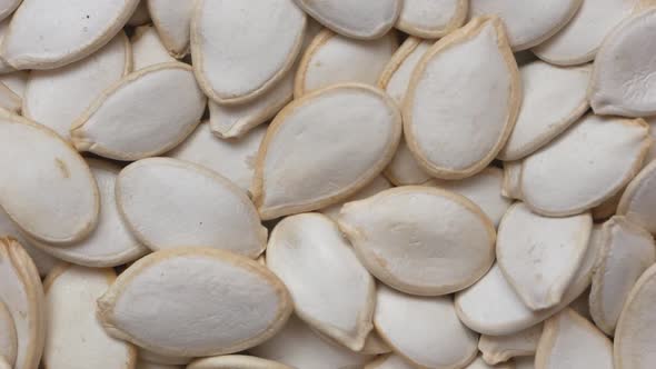 Close-up of a bunch of fresh white pumpkin seeds rotate.