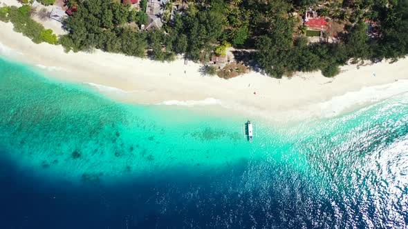 Wide drone tourism shot of a sunshine white sandy paradise beach and aqua blue ocean background in h