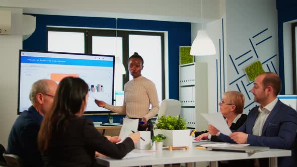 African Project Manager Holding Financial Meeting Showing Statistical Graphs