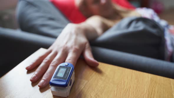 Woman at Home with Pulse Oximeter on Finger