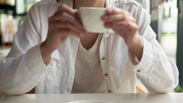 Girl Drinks Coffee Young Woman Raises A Cup Of Coffee While Sitting In A Restaurant Against Windows