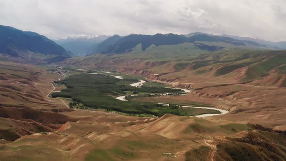 Mountain peaks and grassland under white clouds