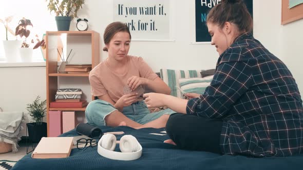 Young Women Playing Cards on Bed