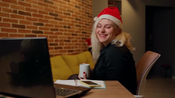 Woman finishing work on laptop on christmas. Female person happy smile and show positive emotions