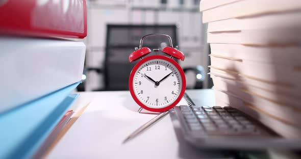 Red Alarm Clock Standing on Table Among Folders with Documents and Calculator  Movie Slow Motion