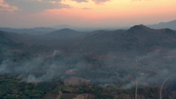 Aerial view of Wildfire filled with flames and toxic fumes from burning on mountains.