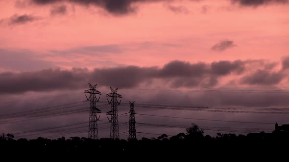 Bright orange dusk sunset setting behind dark ominous storm clouds.