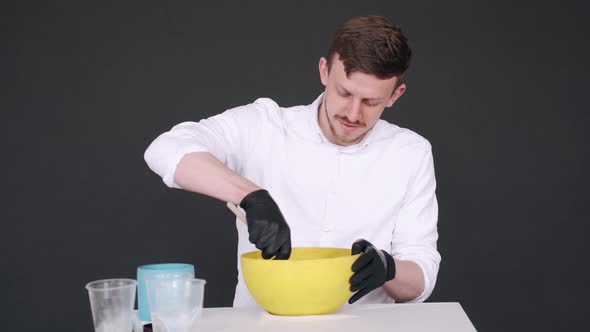 Artist Preparing Mixture for Modling in Yellow Bowl in Studio