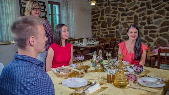 Slow-motion shot of a waitress serving a table of four.