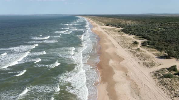 Drone Flight Over the Azure Sea with Waves and Sandy Coast