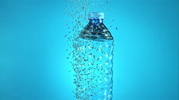 A Bottle of Water with Air Bubbles Under Water
