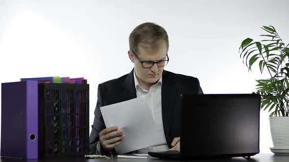 Businessman Working in Office. Making Report Analysis Reading Papers at Table