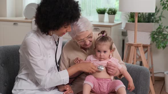 Afro American Woman Doctor While Examining Family of Grandmother and Toddler