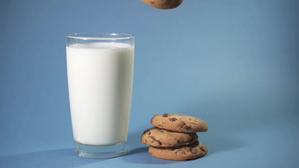 Woman Puts Chocolate Chip Cookies in a Glass with Milk