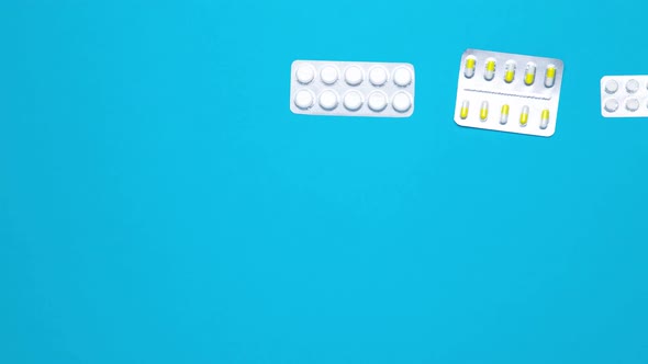 Stop Motion medical pills moves on blue background.