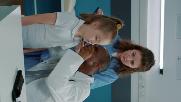 Vertical Video Physician Using Otoscope to Do Ear Examination in Cabinet