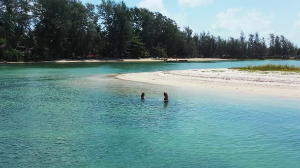 Ladies enjoying life on paradise coastline beach adventure by blue sea with white sand background of