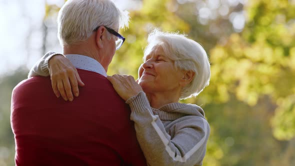 Elderly Caucasian Couple Embracing in Autumn Park