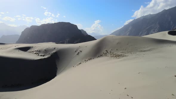 aerial drone flying over a dune in the Cold Desert of Skardu Pakistan on a sunny summer day with lar
