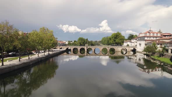 Clouds reflected on Tamega River, flight approaching Roman Bridge, Chaves, Portugal