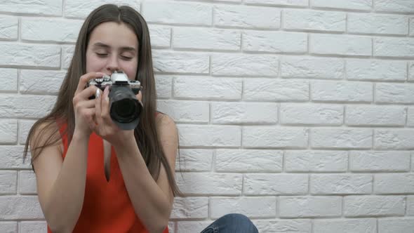 A Girl Looks at a Photo in the Camera