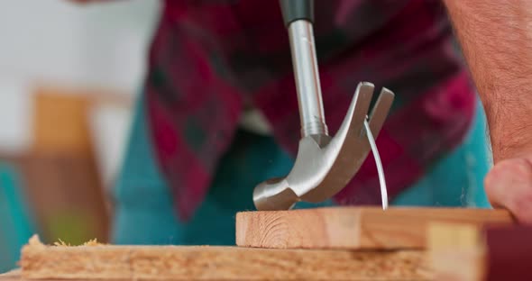 the Carpenter Wearing a Red Flannel Shirt Jeans and Cloth Protective Gloves Pulls Out a Badly Driven