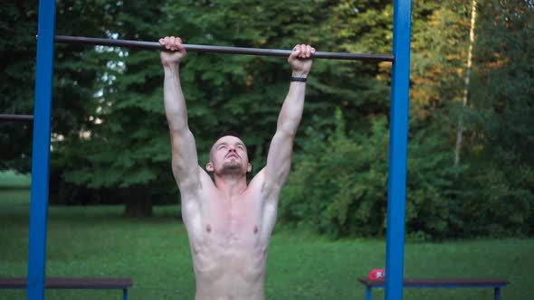 Fitness Man Working Out His Arm Muscles in Outdoor Gym Doing Chinups Pullups As Part of a Workout