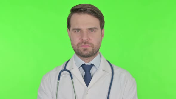 Thumbs Down by Young Doctor on Green Background