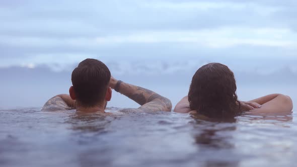 Couple Dipped in a Hot Infinity Pool With the Bright Sky in the Background