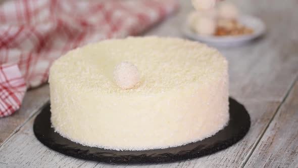 Female Hands Decorate Coconut Mousse Cake with Candy