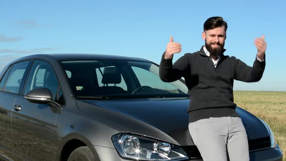 Young Handsome Friendly Happy Man Stands By His New Car and Shows with Arms Come Here - Invite